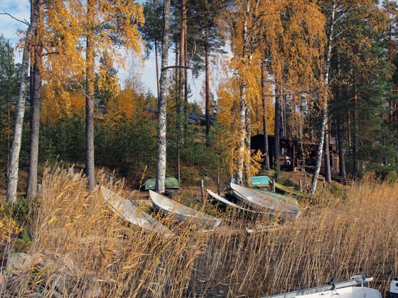Rantasauna ja veneitä rannassa venelaiturilta nähtynä.
